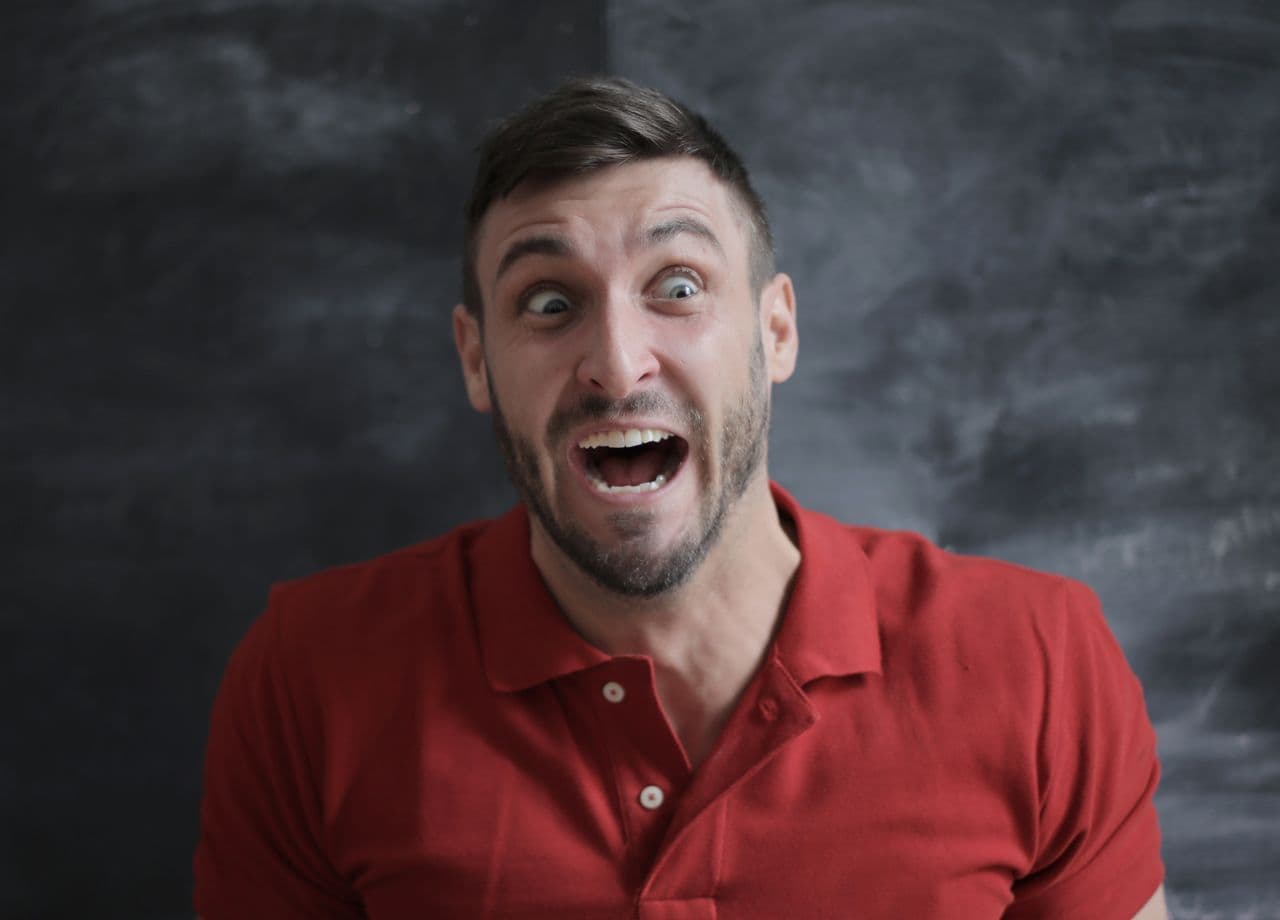 Presenter with a wide-eyed shocked reaction against a chalkboard, used as a sample thumbnail. Photo by Andrea Piacquadio on Pexels